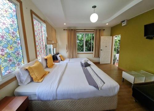 1 dormitorio grande con 1 cama grande y 2 ventanas en 88 Backpackers Hua Hin, en Hua Hin