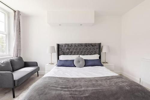 a bedroom with a large bed and a couch at Lovely 3 bedroom flat in North London in London