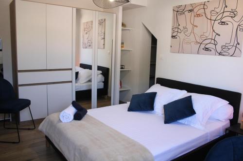 a bedroom with a bed with white sheets and a mirror at 36 2 L'air marin maison duplex grande terrasse in Narbonne