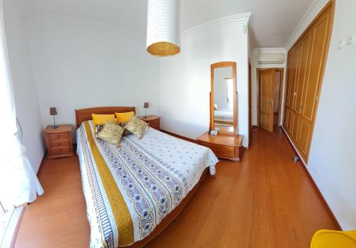 een slaapkamer met een bed en een houten vloer bij VILLA DO LIMAO in Tavira