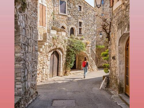 une femme marchant dans une rue dans une allée dans l'établissement La Poussinière, à Aiguèze