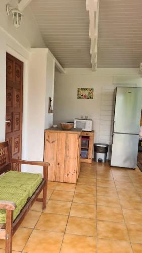 a kitchen with a refrigerator and a wooden floor at Grand bungalow avec piscine et vue mer in Bouillante