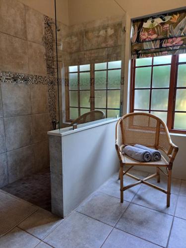 a bathroom with a tub and a chair and windows at Elvandar Country Cottage in Hilton
