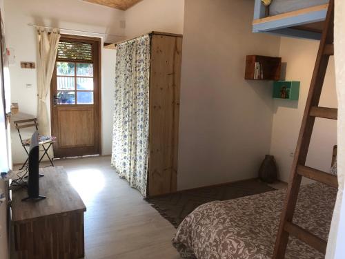 1 dormitorio con cama, ventana y escalera en Bungalow 4 épices, en Saint-Leu