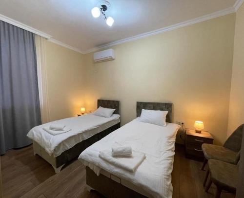 a hotel room with two beds and a chair at Hotel Mogzauri, Khulo in Khulo