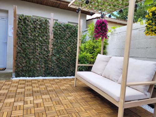 a swing on a patio with a hedge at Cosy Paris CDG Stade de France in Le Blanc-Mesnil