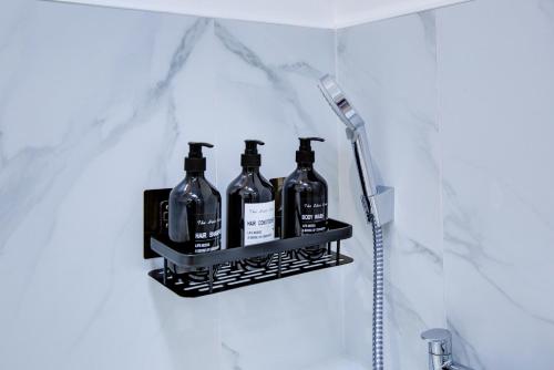 a shelf in a bathroom with four bottles on it at Stylish Apt with Balcony and easy central access in London