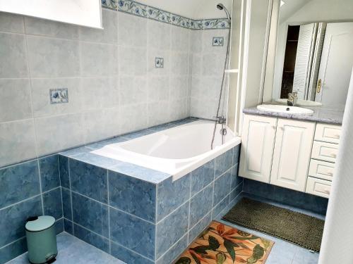a bathroom with a tub and a sink at Gîte de la valleuse, capacité 12 personnes, idéal pour une grande famille in Senneville-sur-Fécamp