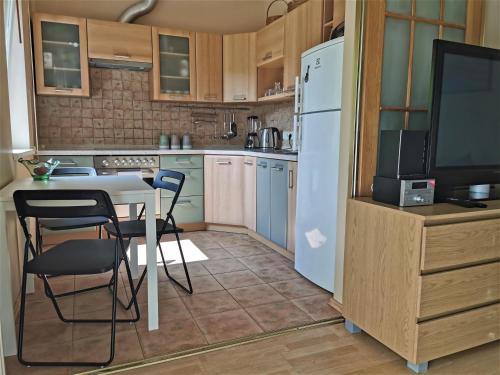 cocina con mesa, sillas y nevera en Flip-Flops Apartment Jurmala with free parking, en Jūrmala