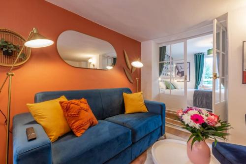 - un canapé bleu dans le salon avec un miroir dans l'établissement Esope-Ravissant T2 en plein centre de Château-Thierry, à Château-Thierry