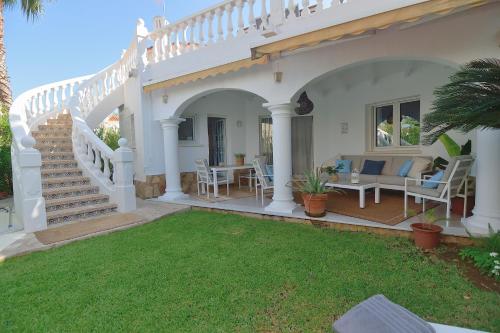 a white house with a patio with a table and chairs at Villa Renoir by Goveralia in Oliva