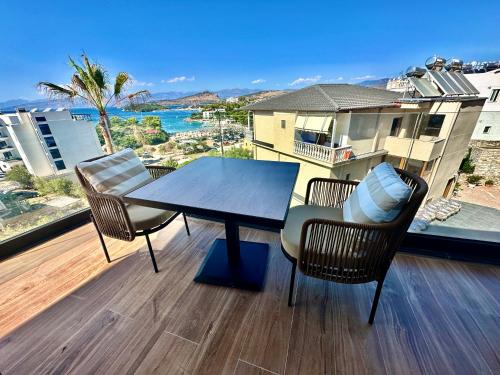 a table and chairs on a balcony with a view of the ocean at Nobbu Hotel Ksamil in Ksamil