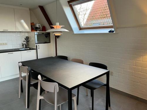 a kitchen with a table and chairs and a window at Vakantiewoning Sneekermeer, huur sloep of zeilboot mogelijk in Goingarijp