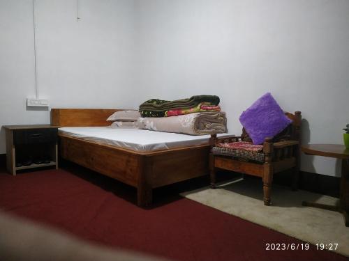 een slaapkamer met een houten bed en een stoel bij Dawn Home Stay in Darjeeling