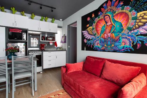 a living room with a red couch and a kitchen at VIVA LA VIDA in Mexico City