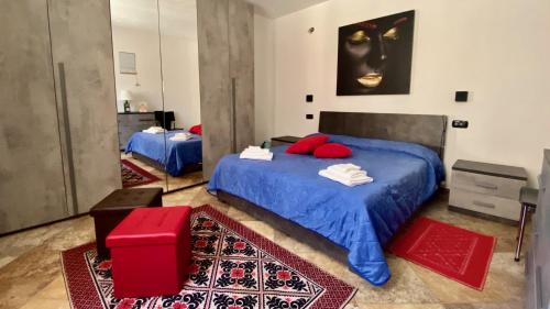 a bedroom with a blue bed with red pillows at Fadda Holiday House - Managed By Antonio Sanna in Austis