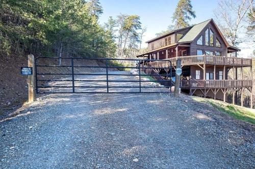 a gate in front of a wooden house at Mistletoe Cabin- Private cabin w views, Hottub, pet friendly in Murphy