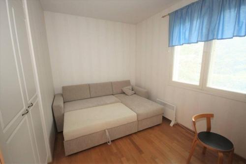 Habitación pequeña con sofá y ventana en Omakotitalo 4-6 hengelle - House, en Lahti