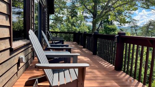 three chairs sitting on the porch of a house at Mistletoe Cabin- Private cabin w views, Hottub, pet friendly in Murphy