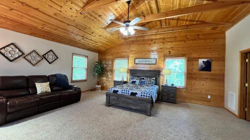 a living room with a bed and a ceiling fan at Mistletoe Cabin- Private cabin w views, Hottub, pet friendly in Murphy
