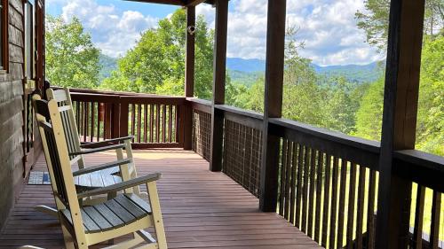 a porch with two chairs and a view of the mountains at Mistletoe Cabin- Private cabin w views, Hottub, pet friendly in Murphy