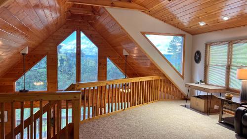a room with a staircase with large windows at Mistletoe Cabin- Private cabin w views, Hottub, pet friendly in Murphy