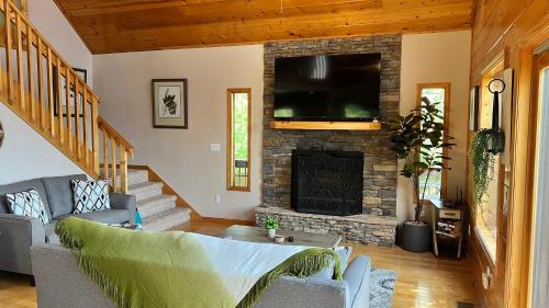 a living room with a fireplace and a tv at Mistletoe Cabin- Private cabin w views, Hottub, pet friendly in Murphy