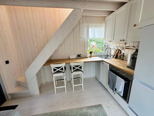 a kitchen with two stools in the middle of it at Fully equipped new tiny-house in Kuressaare