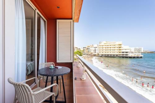 a balcony with a table and chairs and a view of the beach at Amazing Beachfront Property CASA CORINA I in El Médano