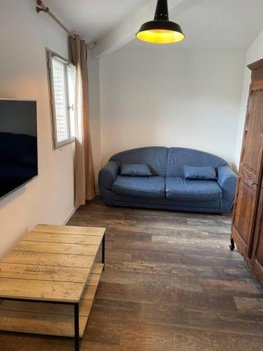 un canapé bleu dans un salon avec une table dans l'établissement Appartement T2 - 2e étage, à Seysses