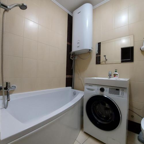a bathroom with a washing machine and a washer at 2кк люкс 3-я Слободская/Кузнецкая in Mykolaiv