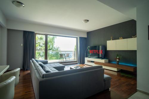un soggiorno con divano e una grande finestra di With a View Residence - Luxury Apartament - Panoramic view over the City a Braşov