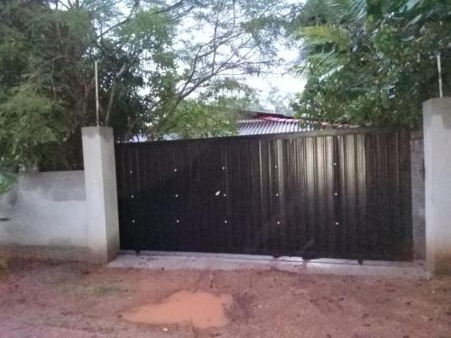 a black fence with a dog standing in front of it at Kitula family guest house in Anuradhapura