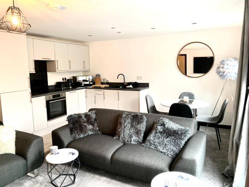 a living room with a couch and a kitchen at Mill Bank Apartment in Todmorden