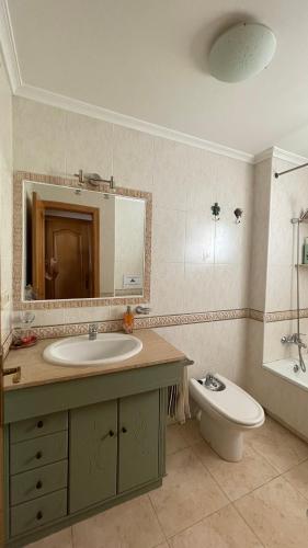 a bathroom with a sink and a toilet and a mirror at Cala AZUL Gran Terraza con BBQ in Cabo de Palos