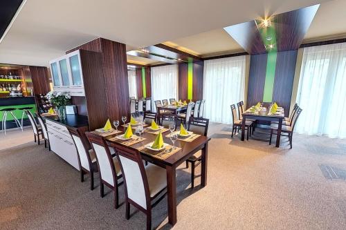 uma sala de jantar com mesas e cadeiras de madeira em Klub Hotel em Dunaújváros