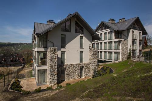 a large house on top of a hill at udanypobyt Apartamenty Smrekowa in Zakopane