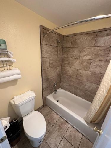 a bathroom with a toilet and a bath tub and a toilet at Relax Inn of Medford in Medford