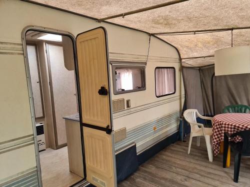 an open door of a caravan with a table at Camping - Park Władysławowo in Władysławowo