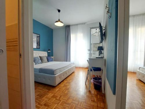 a bedroom with blue walls and a bed and a wooden floor at MyWay Trieste Rooms in Trieste
