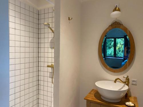 ein Bad mit einem Waschbecken und einem Spiegel in der Unterkunft Gamle Præstegård in Fåborg