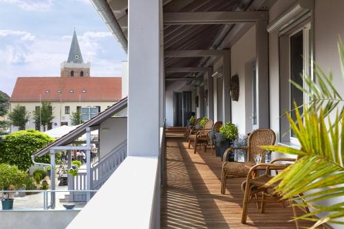 Un balcón con mesas y sillas y una iglesia. en Pension Schlossgasse, en Lieberose