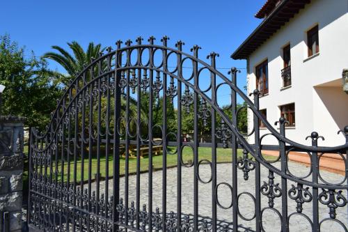 una puerta negra de hierro forjado frente a una casa en Villa El Martín en Naves