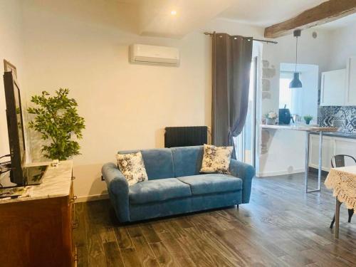 a living room with a blue couch and a kitchen at Nel cuore di Alvito, appartamento in centro in Alvito