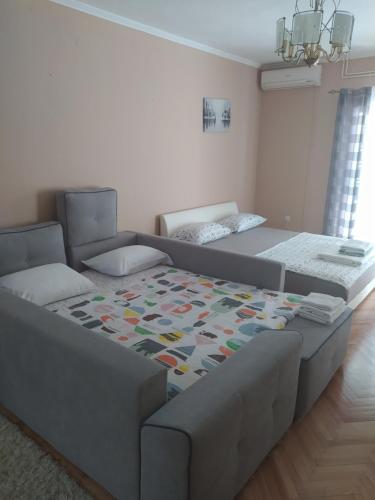 - un salon avec deux lits et un canapé dans l'établissement Apartmani Most, à Trebinje