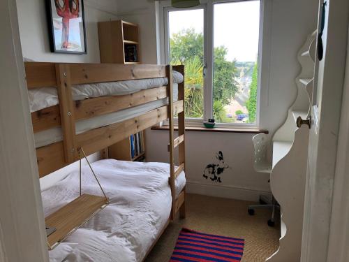 1 dormitorio con 2 literas y ventana en Sunnyview 5-Bed House in Kingsbridge with parking en Kingsbridge