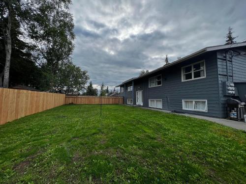 um quintal em frente a uma casa com uma cerca em Anchorage midtown apartment-Wyoming 2 em Anchorage