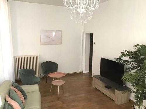 Una sala de estar con un sofá y una lámpara de araña. en Hypercentre (avec parking), rare avec 3 chambres 3 salles d’eau, en Albi