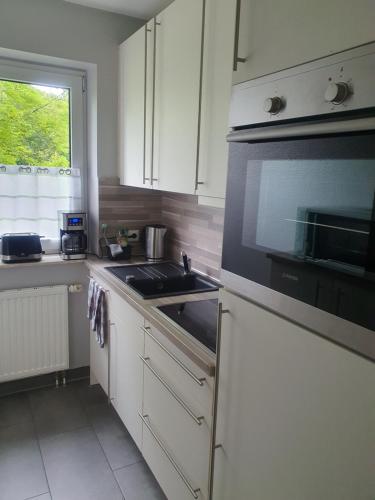 a kitchen with a sink and a microwave at Mövenschiss in Wremen