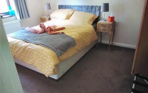 a bedroom with a bed with a doll on it at Self-catering guest annex in Norwich